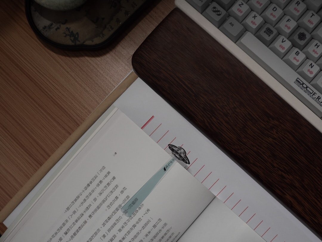 Vintage typewriter on a wooden desk with a notebook and dim lamp light